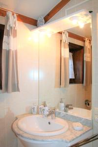 uma casa de banho com um lavatório, um espelho e uma banheira em Village Park P25 em De Haan