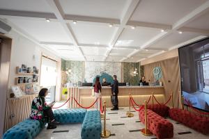 a lobby with couches and a waiting room with people at P.C. Boutique H. Castel Nuovo, by ClaPa Group Dislocated Hospitality in Naples