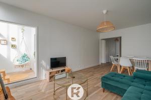 uma sala de estar com um sofá verde e uma mesa em R 'AppartsT3 Serenity Haven em Torcy