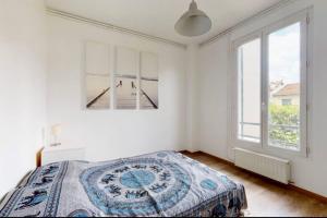 a white bedroom with a bed and two windows at Maison / Porte de Versailles in Vanves