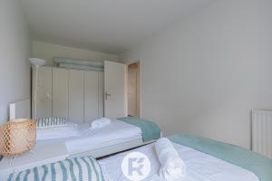 twee bedden in een kamer met witte muren bij R 'AppartsT3 Serenity Haven in Torcy