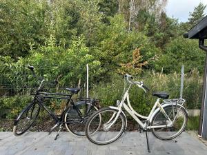 twee fietsen naast elkaar geparkeerd op een patio bij Dom z sauną na wyłączność in Drawno