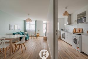 een keuken en een woonkamer met een tafel en een eetkamer bij R 'AppartsT3 Serenity Haven in Torcy