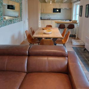 a living room with a couch and a table and chairs at Zeepolder I 45 in De Haan