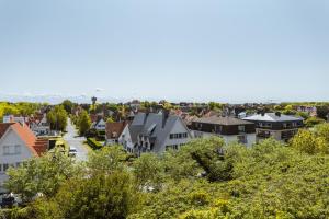 uma vista para uma cidade com casas e árvores em May Fair 0412 em De Haan