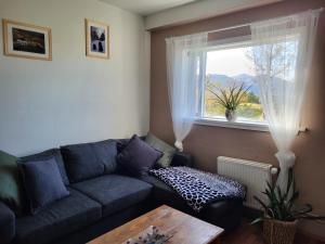 sala de estar con sofá y ventana en Hvanneyri apartment en Hvanneyri