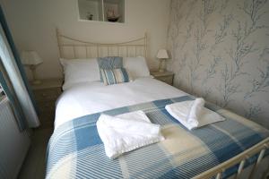une chambre avec un lit avec des serviettes dessus dans l'établissement Cranny Cottage Carnlough, à Carnlough