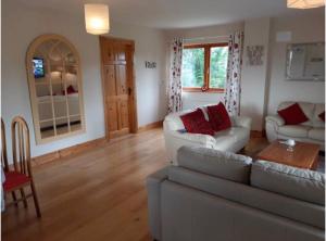 a living room with a couch and a table at The Lake House Apartment in Drumshanbo +4 photos