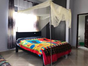 - une chambre avec un lit à baldaquin et un miroir dans l'établissement Fort Marigold Hotel, à Fort Portal