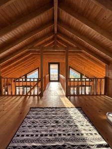 Cette grande chambre en bois dispose d'un tapis et de parquet. dans l'établissement Stylish Bungalow Villa In City, à Yakuplu