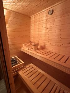 a small wooden sauna with a bucket in it at Dom z sauną na wyłączność in Drawno