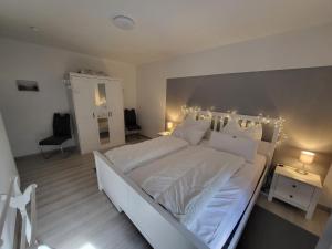 - une chambre avec un grand lit blanc éclairé dans l'établissement FW Niedner, à Altenau