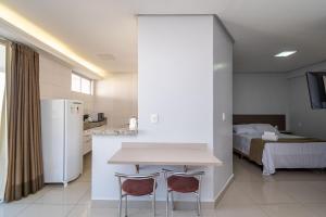 um quarto com uma mesa e duas cadeiras e uma cama em Onix Bueno Residence - ONX em Goiânia