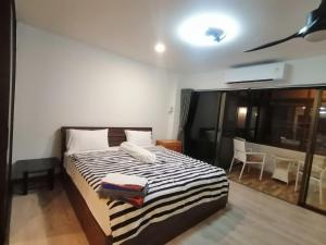 a bedroom with a bed with a black and white striped blanket at Jomtien Hill Resort Pratamnak in Pattaya South