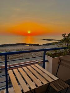 a bench sitting on a balcony watching the sunset at TRAMONTO Suite-Rome Airport FCO-Fronte mare in Fiumicino