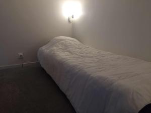 uma cama num quarto com uma luz na parede em Appartement Risoul, 1 pièce, 4 personnes - FR-1-330-530 em Risoul
