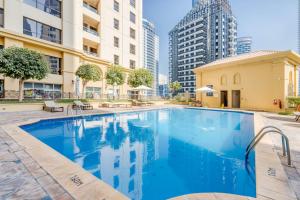 a swimming pool in the middle of a city with buildings at GLOBALSTAY. Modern Apartments steps to JBR Beach in Dubai