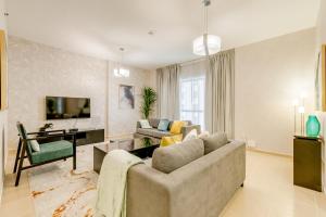 a living room with a couch and a tv at GLOBALSTAY. Modern Apartments steps to JBR Beach in Dubai