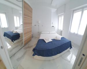 a white room with a bed and a mirror at Appartamenti Reali Bonaccini in Milan