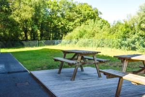 tres mesas de picnic en una terraza de madera en un parque en ibis budget Rodez en Rodez
