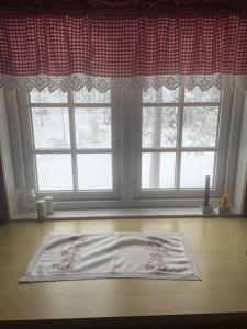 una ventana con una alfombra en el suelo delante de ella en Svingom - hytte uten strøm og vann 