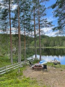 una mesa de picnic y sillas junto a un lago en Svingom - hytte uten strøm og vann 