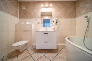 uma casa de banho com um WC, um lavatório e uma banheira em Hotel Gromada Poznań em Poznań