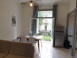 a living room with a table and chairs and a window at Grand T2 calme et cosy au « Pyrénées Palace » in Luchon