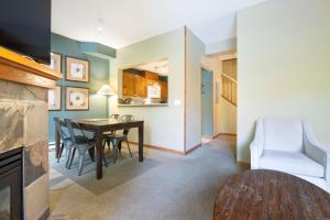 a dining room and living room with a table and chairs at Whistler Vacation Club at Twin Peaks in Whistler