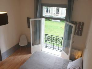 a bedroom with a bed and a large window at Grand T2 calme et cosy au « Pyrénées Palace » in Luchon