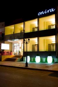Onira Boutique في تولو: مبنى مضاء في الليل مع ضوء الشارع