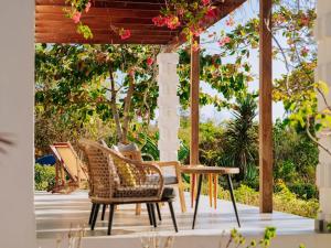 a group of chairs and a table on a patio at Karabai Villa in Matemwe