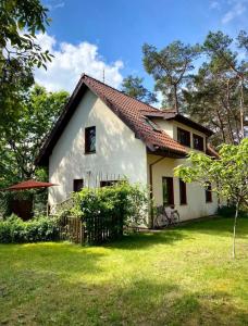une maison blanche avec un toit rouge dans l'établissement Domek na Sosnowej, à Pobierowo