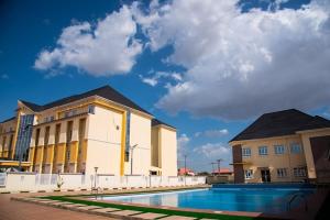 ein Gebäude mit einem Pool vor einem Gebäude in der Unterkunft CRISPAN SUITES & EVENT CENTRE in Jos