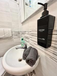 un bagno con lavandino e un dispenser di asciugamani sul muro di Residence Zar 1 a Trieste