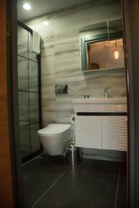 a bathroom with a toilet and a sink and a mirror at Ceneviz Suit Hotel in Akçakoca