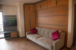 sala de estar con sofá y 2 almohadas rosas en Ceneviz Suit Hotel en Akcakoca