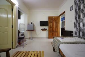 - une chambre avec un lit, une télévision et une porte dans l'établissement Stayhome Suites, à Bangalore