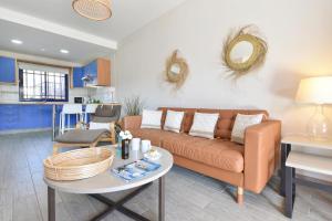 a living room with a couch and a table at Meloneras Bahia 28 by VillaGranCanaria in Meloneras