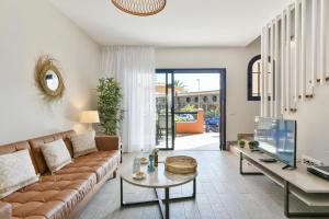 a living room with a couch and a tv at Meloneras Bahia 28 by VillaGranCanaria in Meloneras