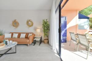 a living room with a couch and a table at Meloneras Bahia 28 by VillaGranCanaria in Meloneras
