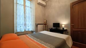 トリノにあるLA QUALITA' AL QUADRATOのベッドルーム(ベッド1台、窓、テレビ付)