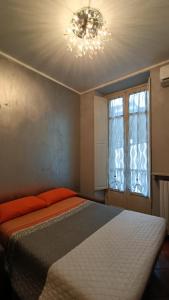トリノにあるLA QUALITA' AL QUADRATOのベッドルーム1室(シャンデリア、窓付)
