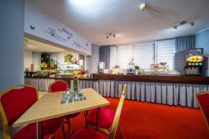 a restaurant with a table and chairs and a counter at Hotel Gromada Poznań in Poznań