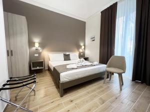 1 dormitorio con 1 cama y 1 silla en Nove Volte B&B, en Catania