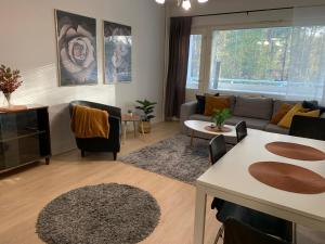 a living room with a couch and a table at 2BR Apartment, free parking - Peikontie in Oulu