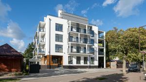 un edificio de apartamentos blanco al lado de una calle en Apartamenty Sun & Snow Villa Solny en Ustronie Morskie