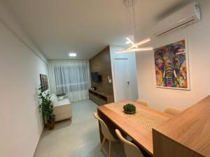 una sala da pranzo con tavolo e un soggiorno di Edifício Promenade II Apt 303- Mandi Hospitalidade a Maceió