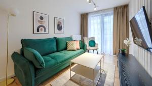 sala de estar con sofá verde y mesa en Apartamenty Sun & Snow Villa Solny en Ustronie Morskie
