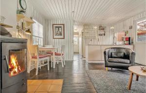 a living room with a fireplace and a dining room at Nice Home In Sydals With Wifi in Østerby